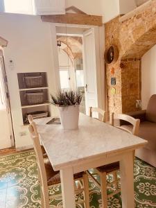 eine Küche und ein Esszimmer mit einem Tisch und Stühlen in der Unterkunft Le Casette Di Brando E Nico in Tricase