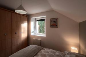 a bedroom with a bed and a window at Gîte Sous le Verger in Songeson