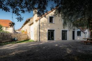 a white house with a wooden fence and a bench at Gîte Sous le Verger in Songeson