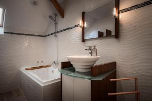 a bathroom with a sink and a bath tub at Gîte Sous le Verger in Songeson +23 photos