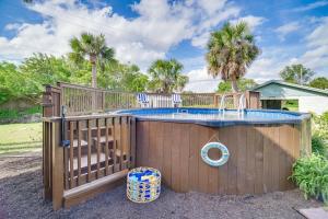 una piscina con una valla de madera y una terraza en Moon Beach Manor with Private Pool and Hot Tub! en Cocoa Beach