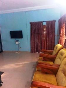 a living room with a couch and a flat screen tv at Appartement en location in Lomé