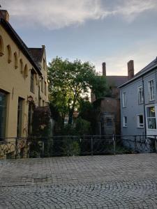 une rue pavée avec des bâtiments et une clôture dans l'établissement Suite L'Ane city center & parking, à Bruges