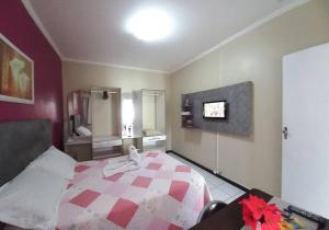 a bedroom with a bed with a red and white quilt at Apartamento Mobiliado temporada in Aracaju
