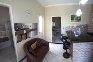 a living room with a leather couch and a counter at Apartamento Mobiliado temporada in Aracaju