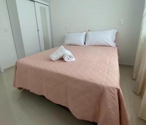 Una cama con dos toallas encima. en Apartamento Novo 500m da praia de Itajuba, en Barra Velha