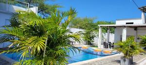 a pool with palm trees next to a building at Cabaña El Faro in Tubará