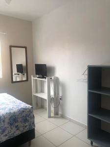 1 dormitorio con 1 cama y escritorio con ordenador portátil en Comodidade e simplicidades a 240m do mar, en Florianópolis