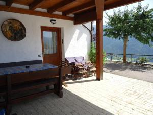 eine Veranda eines Hauses mit einem Tisch und Stühlen in der Unterkunft Agriturismo Mangiasa in Malè