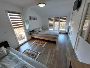 sypialnia z 2 łóżkami i 2 oknami w obiekcie CABANA CASA LU'BACIU w mieście Arpaşu de Sus