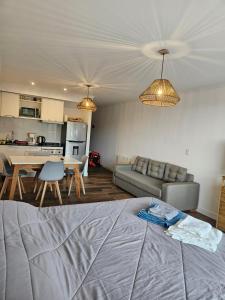 sala de estar con sofá, mesa y cocina en Monoambiente a estrenar en Bariloche en San Carlos de Bariloche