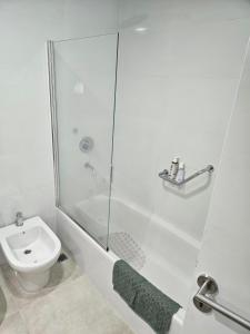uma casa de banho branca com um chuveiro e um WC. em Monoambiente a estrenar en Bariloche em San Carlos de Bariloche