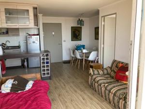 een woonkamer met een bank en een keuken bij Egeo mariposa in Viña del Mar