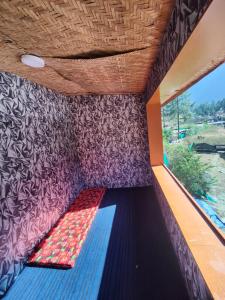ein Bett in einem Zugwagen mit Fenster in der Unterkunft Circle Square in Kasol