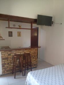 una habitación de hotel con un bar con dos taburetes en Ap Buzios, en Búzios