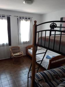 1 dormitorio con 2 literas y 1 silla en Casa Pelagia, maison de pêcheur avec amarre, en Empuriabrava