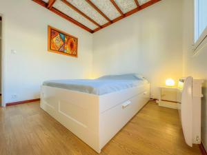 ein Schlafzimmer mit einem weißen Bett in einem Zimmer in der Unterkunft Maison Familiale - Torreira in Torreira