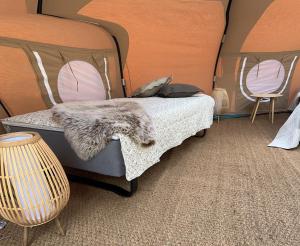 Idestrup的住宿－Romantik Luxus Glamping 2，一间卧室配有一张带毯子的床和两把椅子