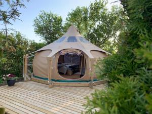 Idestrup的住宿－Romantik Luxus Glamping 2，木甲板上的大型帐篷,种有树木
