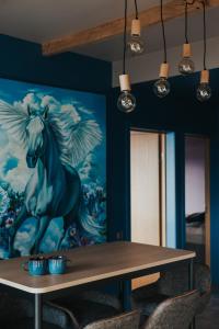 una mesa con un cuadro de un caballo en la pared en Zilais Zirgs, en Skrīveri