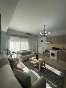 ein Wohnzimmer mit einem Sofa und einem Tisch in der Unterkunft Sindos House SKG in Síndos