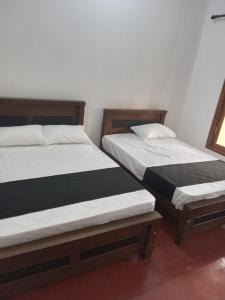 dwa łóżka siedzące obok siebie w pokoju w obiekcie VILLA AAA WELIGAMA w mieście Weligama