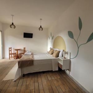 a bedroom with a bed and a table in it at Pousada Flor do Campo Cipó in Santana do Riacho