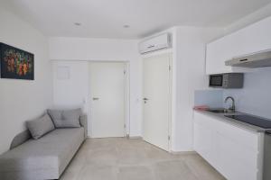 uma sala de estar com um sofá e uma cozinha em Apartment R A M L J A K "Andrija" em Vodice