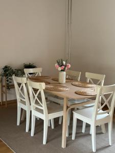 uma mesa de jantar branca e cadeiras com flores em Your Cozy City Bungalow em Baden