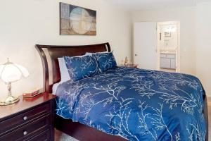 a bedroom with a bed with a blue comforter at Lake Cortez Cottage 