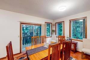 a dining room with a table and chairs and windows at The Pony Creek Forest Retreat in North Bend