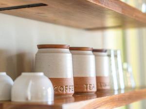 a row of coffee cups sitting on a shelf at Beachfront Apartment near Bocas Town in Istmito