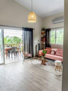 een woonkamer met een roze bank en een tafel bij Seaside Apartment near Bocas Town in Istmito