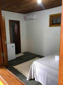 Chalé Casa Vitoria - Quarto Inferior في ترانكوسو: غرفة نوم بسرير وغرفة بها سخان
