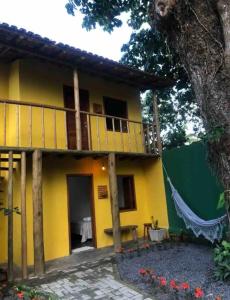 a house with a yellow and green facade at Chalé Casa Vitoria - Quarto Inferior in Trancoso