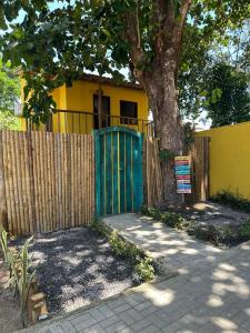 Chalé Casa Vitoria - Quarto Inferior في ترانكوسو: حاجز ببوابه زرقاء امام شجرة