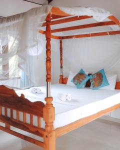 a wooden bunk bed with white sheets and blue pillows at Damith Guest House in Unawatuna