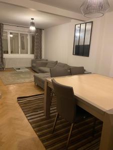 a living room with a table and a couch at Le cottage de Lloyd 4 chambres 2 salles de bain in Bourbourg