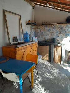 uma cozinha com uma mesa azul e um espelho em Suites na Vila em Maraú