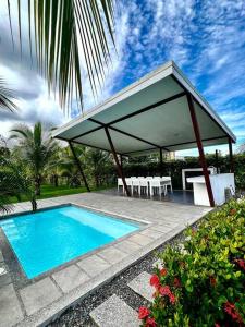 a house with a swimming pool and a pavilion at Modern & convenient condo in Jaco downtown in Jacó