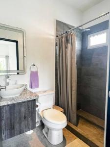 a bathroom with a toilet and a sink and a shower at Modern & convenient condo in Jaco downtown in Jacó