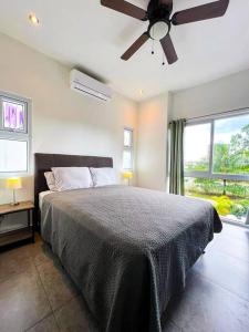 a bedroom with a bed and a ceiling fan at Modern & convenient condo in Jaco downtown in Jacó