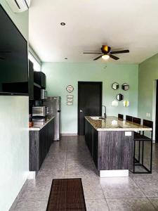 a kitchen with green walls and a ceiling fan at Modern & convenient condo in Jaco downtown in Jacó