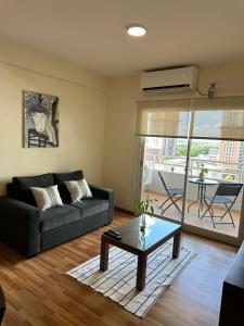 a living room with a couch and a table at Departamento temporal zona Bv Galvez con chochera in Santa Fe