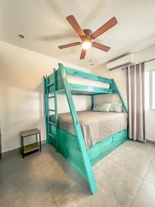 a green bunk bed in a room with a ceiling fan at Modern & convenient condo in Jaco downtown in Jacó