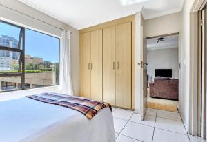 a bedroom with a bed and a large window at Comfort Apartment SA in Johannesburg