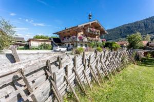 una valla de madera frente a una casa en Ferienwohnungen am Biobauernhof Lahner, en Bramberg am Wildkogel