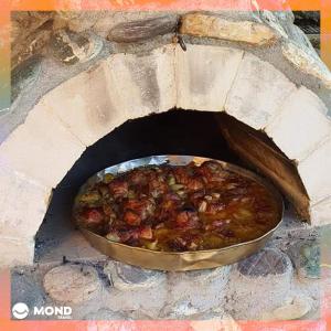 a pan of food in a brick oven at Vila Sara in Mavrovi Anovi