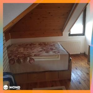 Cama grande en habitación con suelo de madera en Vila Sara en Mavrovi Anovi