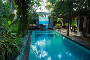 平谷Serene Villa Hiriketiya的院子里有一个蓝色水的游泳池
